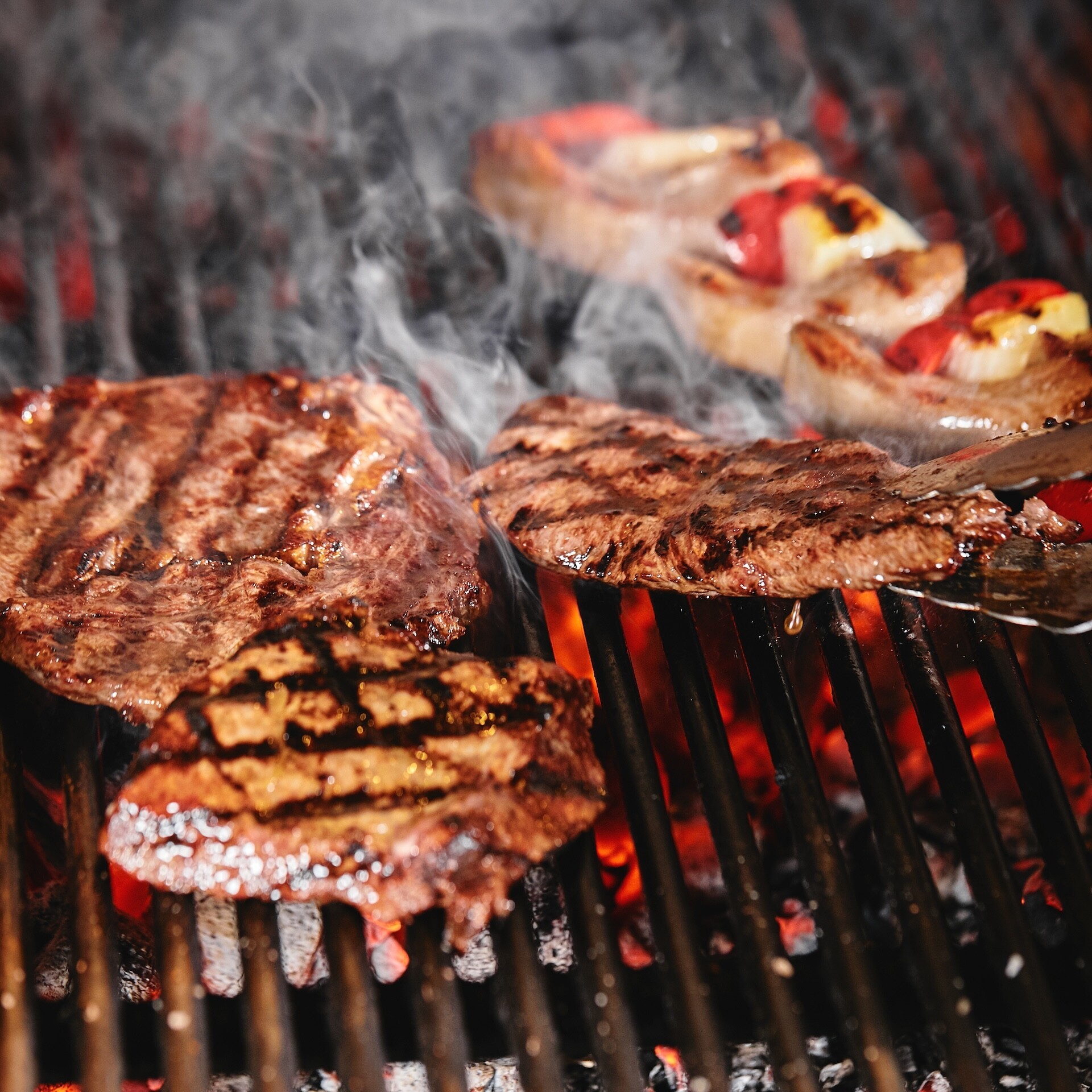 Juicy beef steak flips in a barbecue flame, life style, food photo, copy space.